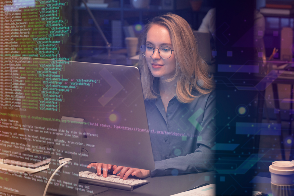 A woman at her desk looking at her computer programming.