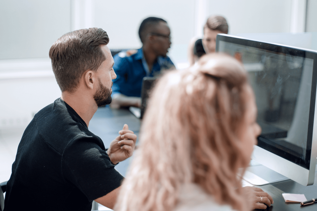 A group of people on a computer in a meeting.